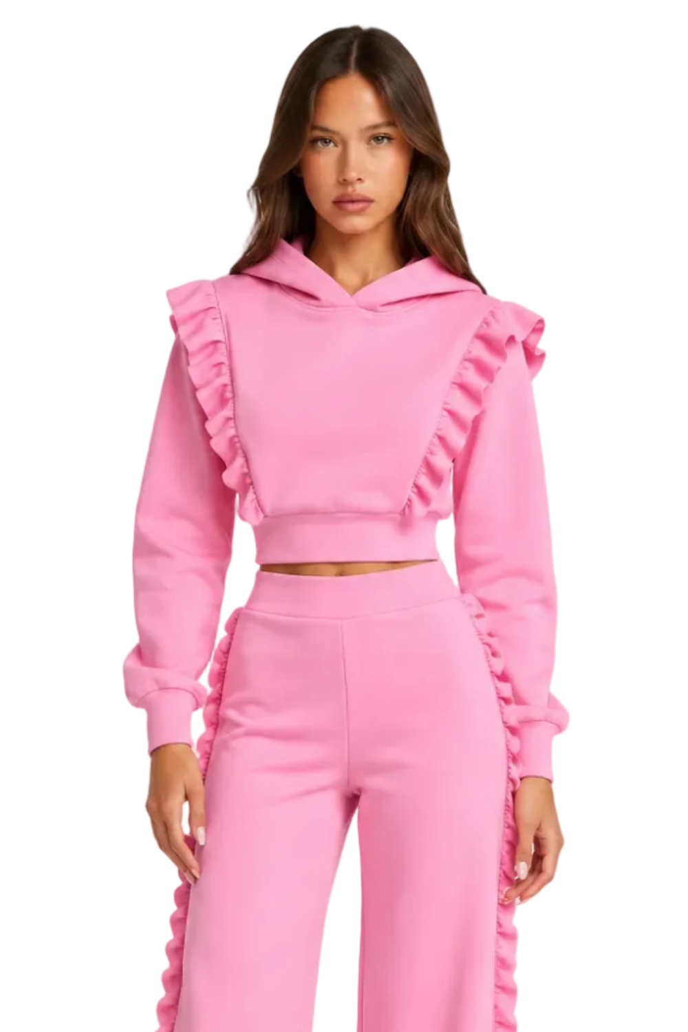 A model wearing a bright pink two-piece tracksuit featuring a cropped hoodie with ruffle details on the shoulders and sleeves, paired with matching wide-leg ruffle-trimmed pants, against a plain white studio background.