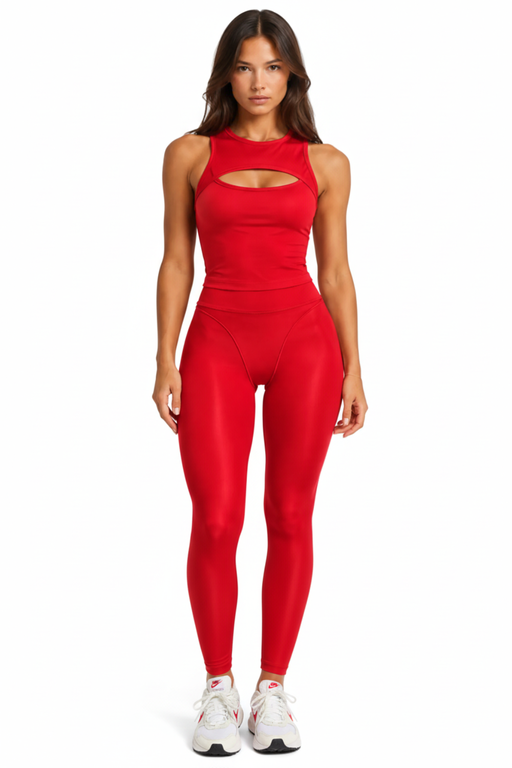 A woman modeling a bright red sleeveless bodysuit with a high mock neck and a horizontal chest cutout, paired with matching red leggings, against a plain white studio background.